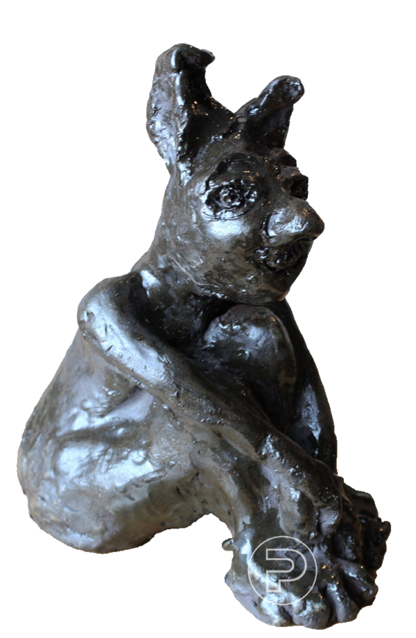 Sculpture d'argile peinte à l'acrylique représentant un homme lapin complètement noir, au regard triste et inquiet, assis avec les bras timidement croisés sur ses genoux pliés devant lui.